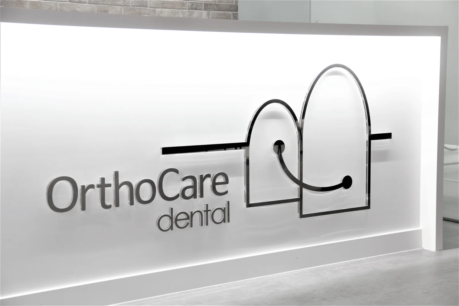 Mostrador de recepción con el logo de Orthocare dental